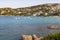 Colourful View looking at Cala Batistoni Beach and a Turquoise Mediteranean Ocean with Granite Coast and Pedalos: Baia Sardinia, G