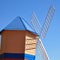 Colourful windmill in bright blue sky