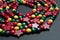 Colourful wooden Christmas decorative beads arranged in a spiral on a neutral surface