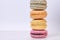 Column of colored macarons on white background