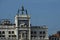 Column with lion of St Mark, symbol of imperial Venice, Zodiac clock Tower and Mother of God in San Marco`s square on the buildin