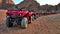 A column of red quads on a desert quadro safari
