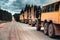 A column of trucks and logging trucks stands on the side of a mountain forest road