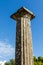 Column of white marble against the blue sky and clouds. Olympia, Peloponnes, Greece