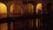 Columns of arch passage with closed stores in night Chioggia