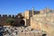 Columns on the hellenistic stoa of the Acropolis of Lindos, Rhodes, Greece, Blue sky, olive tree and beatiful sea view in the back