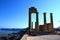 Columns on the hellenistic stoa of the Acropolis of Lindos, Rhodes, Greece, Blue sky, olive tree and beatiful sea view in the back