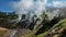 Columns of steam from hot springs rise above the slopes of the mountain.