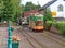 COLYTON, DEVON, ENGLAND - AUGUST 6TH 2012: An orange and green tram pulls into Colyford station on the Seaton tramway. Passengers