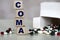 COMA word on a light background with a box of tablets