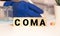 Coma - word from wooden blocks with letters, the complete absence of wakefulness unconsciousness concept, random letters around,