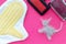 Comb, glove and scissors after cutting the cat and a piece of cat hair in the shape of a cat on a pink background. The view from