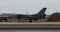 Combat jet aircraft landing in sunny day. Side view with blurred background.