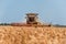 Combine harvester in action on wheat field. Process of gathering a ripe crop.