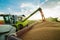 Combine harvester in action on wheat field, unloading grains.