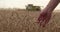 Combine harvester and agricultural machinery harvesting on a sunny day.