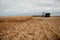 Combine harvester filling a semi for transport