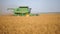 Combine harvester gathering soy beans at sunny day. Harvesting grain field