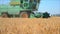 The combine Harvester harvesting in a field of wheat. 60fps