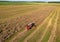 Combine harvester on harvesting oilseed rape in field. Aerial view of harvest season in canola oil field.