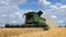 Combine harvester harvesting wheat in a field. UK