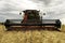 Combine harvester, harvesting wheat, just before a thunderstorm, in Kwazulu Natal, South Africa