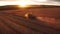 Combine harvester harvests wheat in the field at sunset in autumn in Russia. view from a height of equipment and field