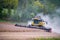 Combine harvester kicks up dust harvesting hillside soy bean crop
