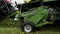 Combine harvester machine carriage collects cutted grass on farm margin