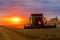 Combine harvester at sunset