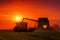 Combine harvester at sunset