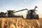 Combine harvester and a tractor working on a wheat field