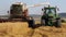 Combine harvester unloading grain into the truck