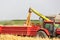 Combine harvester unloading wheat grains into tractor trailer.