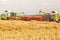 Combine harvester unloading wheat grains into tractor trailer.