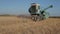 The combine harvester unloads the grain into the truck body. Special agricultural machinery in operation.Old combine harvester mow