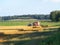 Combine harvester unloads oast in to car trailer