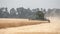 Combine harvester on the wheat field, Green harvester working on the field, view on the combines and tractors working on