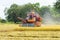 Combine harvester Working on rice field. Harvesting is the process of gathering a ripe crop from the fields