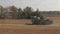 Combine harvesters pass through the autumn field. The beginning of the harvest of cereals. Fresh video news from the fields.