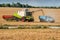 A combine harvests wheat and loads it into a dump truck during the late summer wheat harvest.