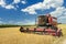 Combine machine with air-conditioned cab harvesting oats on farm field