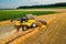 Combine reaper harvests cereals driving past golden wheat