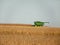 Combine tractor harvesting ripe corn in field