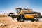 Combine working in agricultural fields. Farmer using combine harvester and collecting corn