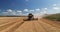 Combine working on harvest agricultural field, aerial drone view