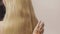 Combing hair on blond with long hair. Closeup