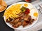 Combo-meal of churrasco with fried potatoes, eggs and baked peppers