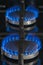 Combustion of natural gas, propane. Gas stove on a black background. Fragment of a gas kitchen stove with a blue flame