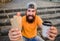 Come hungry, leave happy. Cheerful man with snacks. Happy man holding hot dog and drink. Bearded man smiling with